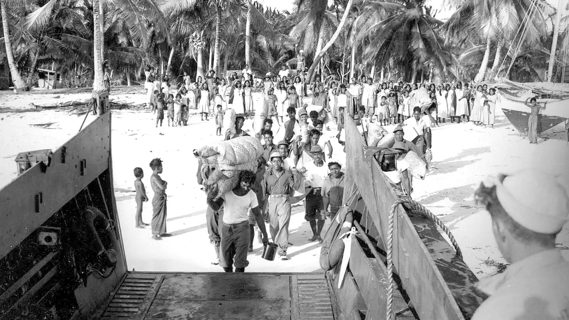Bikini Islanders board a landing craft, vehicle, personnel (LCVP) as they depart from Bikini Atoll in March 1946